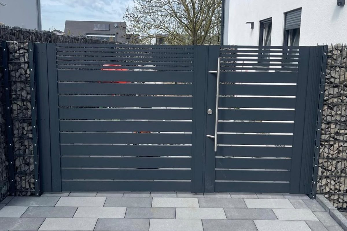 Tor mit waagerechter Lattung, seitlich Gabionen